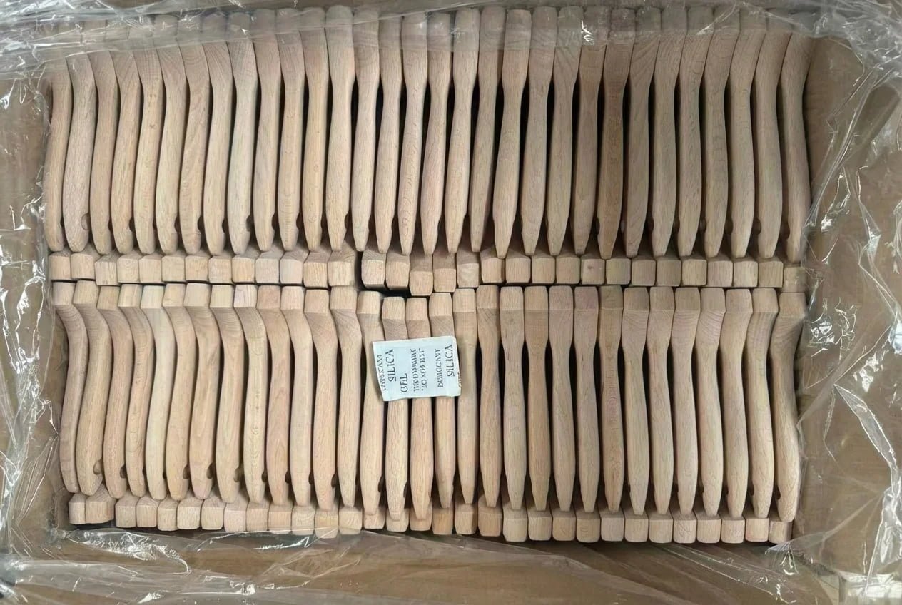 A shipping carton lined with blue plastic and desiccant bags on top of wooden handles