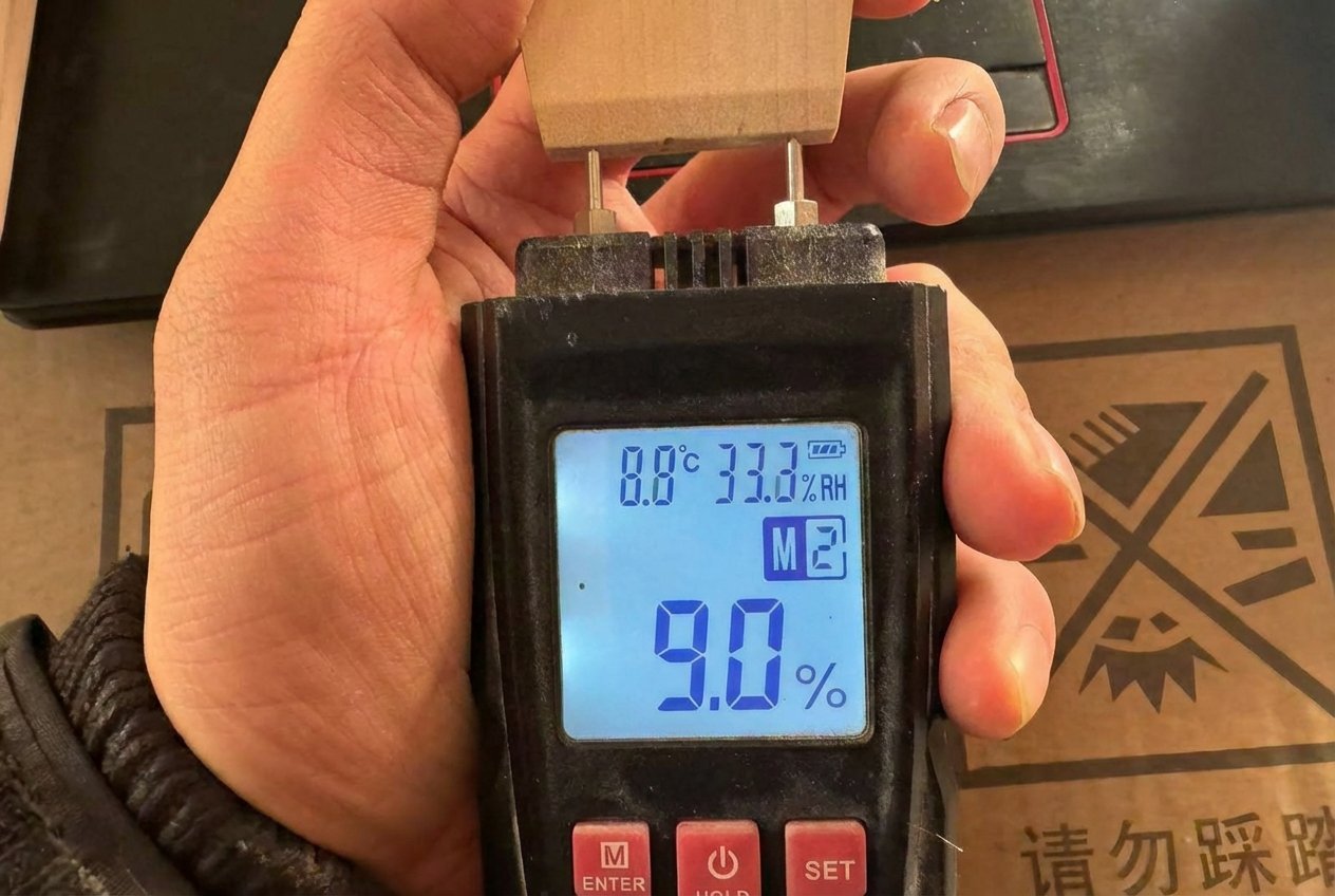 Quality control inspector inserting a moisture meter into the head of a brush handle